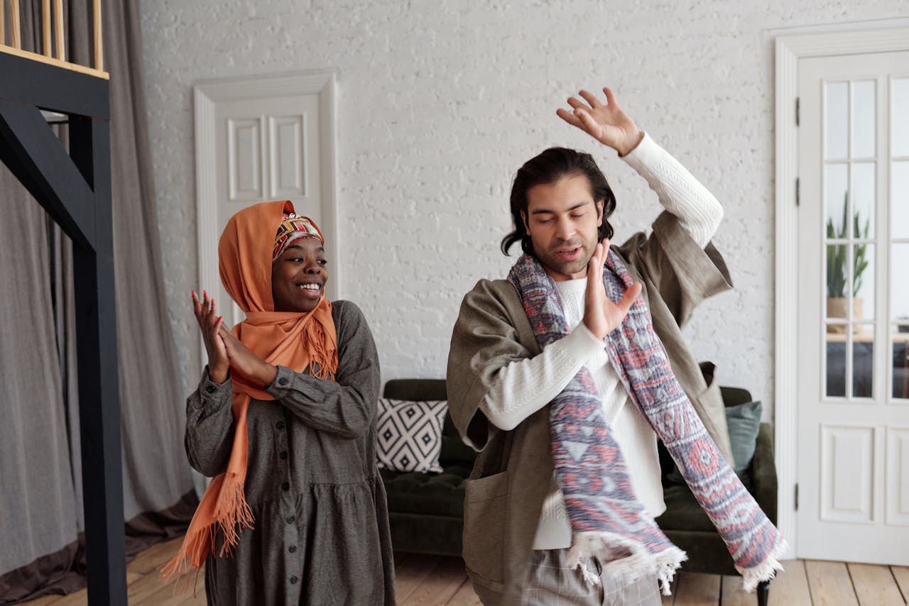 A happy couple dancing indoors, expressing joy and connection in a cozy home setting.